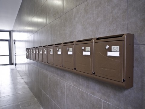 Buzones verticales de interior metálicos pintados en color bronce colgados de pared